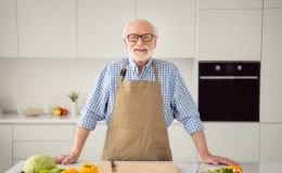 personne agée souriante dans sa cuisine